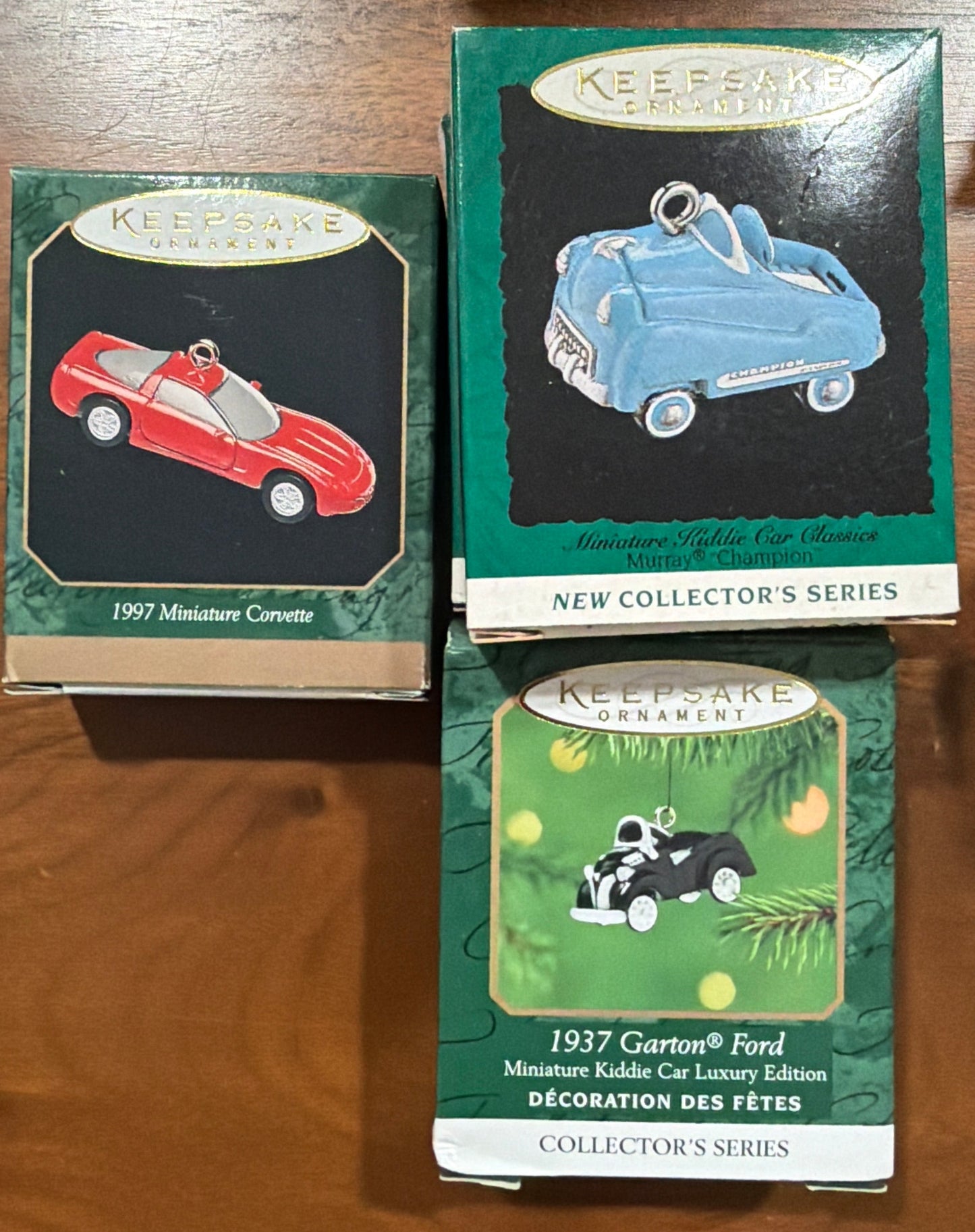 (El precio es por unidad) Esta colección presenta ornamentos Hallmark Keepsake de la Serie Collector, con modelos en miniatura como el camión de bomberos Murray 1996 y el coche infantil Garton Ford 1937.