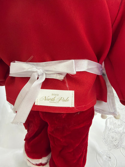 Santa Claus 
Figura de  48 cm, edición 2023 de North Pole Trading. Forma parte de la colección Fabriché y representa a Santa como chef de galletas, con gorro a cuadros rojos y blancos y delantal blanco.