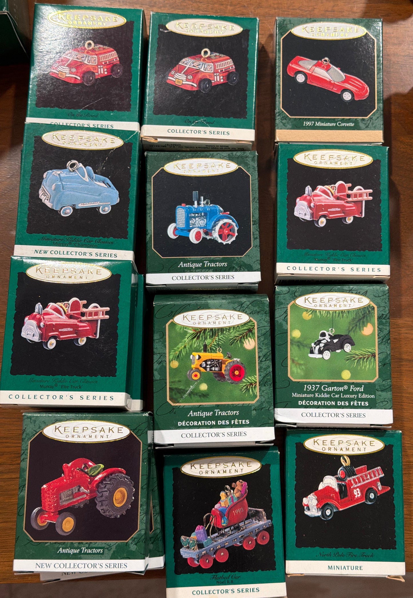 (El precio es por unidad) Esta colección presenta ornamentos Hallmark Keepsake de la Serie Collector, con modelos en miniatura como el camión de bomberos Murray 1996 y el coche infantil Garton Ford 1937.