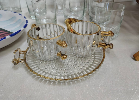 Este conjunto de 3 piezas incluye un plato, un azucarero y una cremera, todos con un elegante borde dorado.
