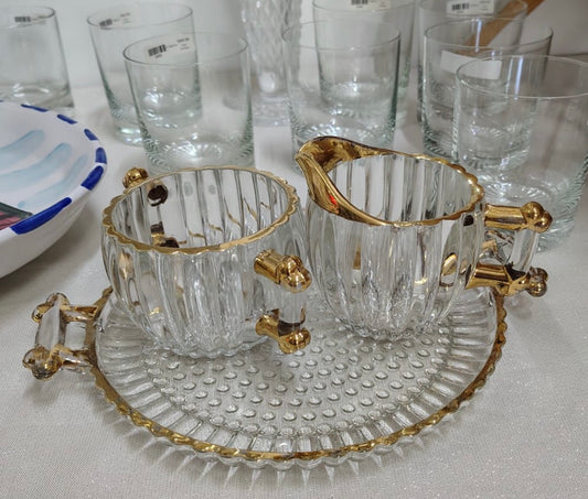 Este conjunto de 3 piezas incluye un plato, un azucarero y una cremera, todos con un elegante borde dorado.