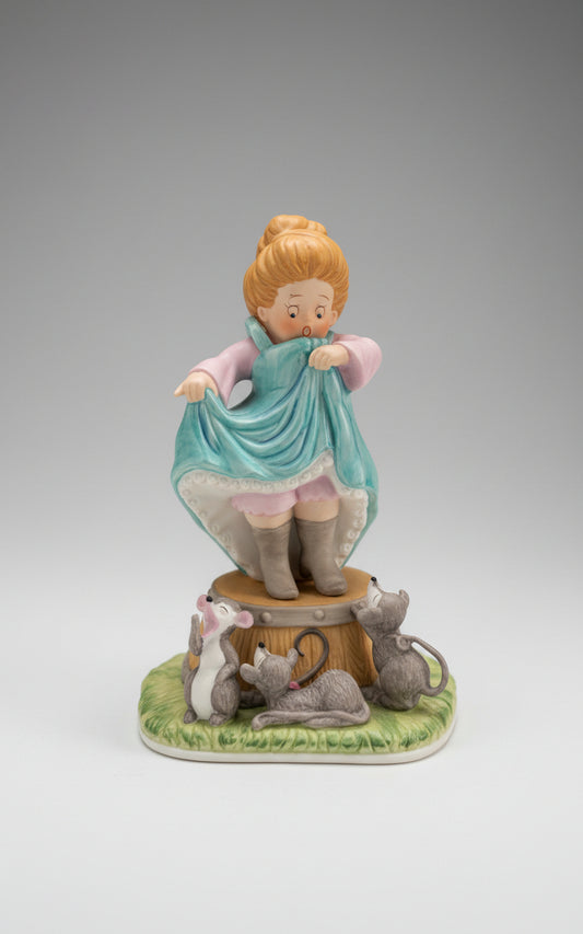 Mabel Lucie Attwell, Representa a una niña con un vestido turquesa, rodeada de ratones y sentada sobre una especie de base, que simboliza el cuento de Cenicienta.