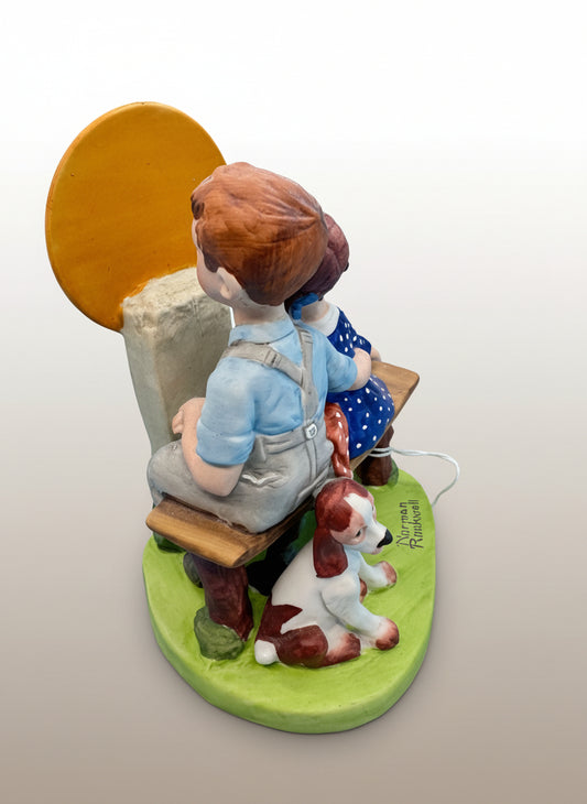 Norman Rockwell, La pieza representa a una pareja joven sentada en un banco, mirando a la luna, con un pequeño perro a su lado. Esta figura fue elaborada a mano en Japón.&nbsp;