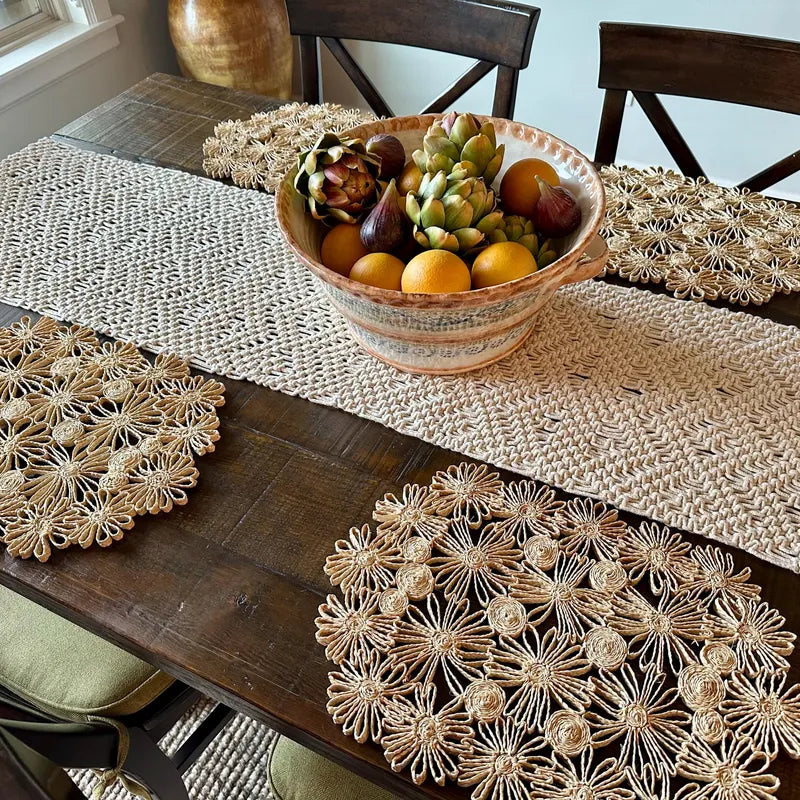 Individual tejido a mano en raffia natural con diseño floral delicado.