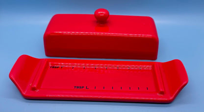 Mantequillera de cerámica esmaltada con tapa y bandeja marcada en cucharadas. Ideal para porcionar con precisión y decorar la cocina con color. Estado: Vintage moderno.&nbsp;
