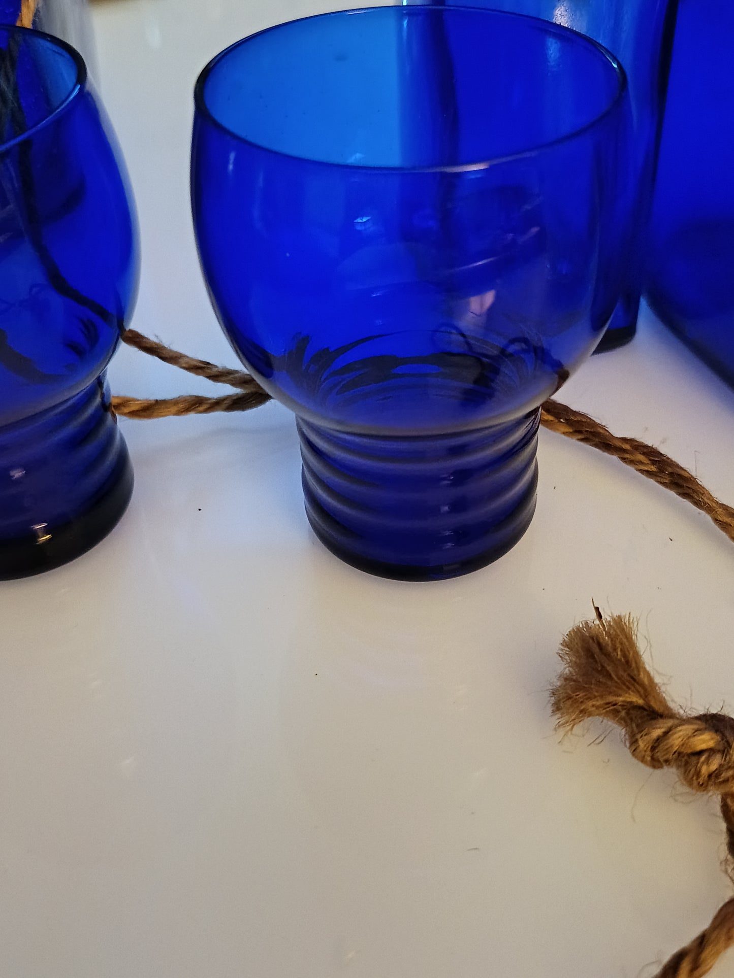 Este set de 2 vasos o  shots tumbler Shaeffer en color azul cobalto, de 3 pulgadas de altura, presenta un diseño clásico de vidrio de depresión.