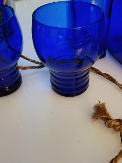 Este set de 2 vasos o  shots tumbler Shaeffer en color azul cobalto, de 3 pulgadas de altura, presenta un diseño clásico de vidrio de depresión.