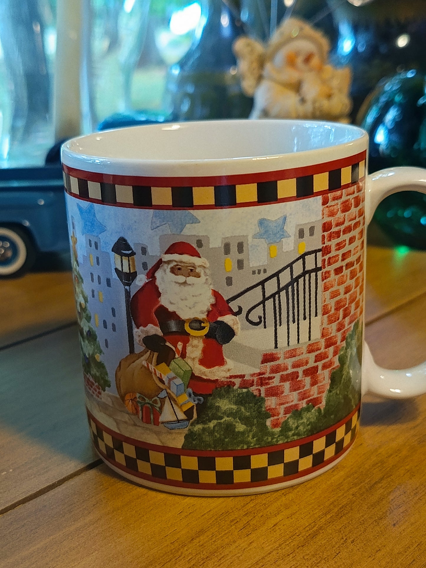 Este set de 4 tazas navideña de café "Santa's Spirit" de Debbie Mumm para Sakura tiene una capacidad de 12 onzas y un diseño navideño con borde a cuadros.