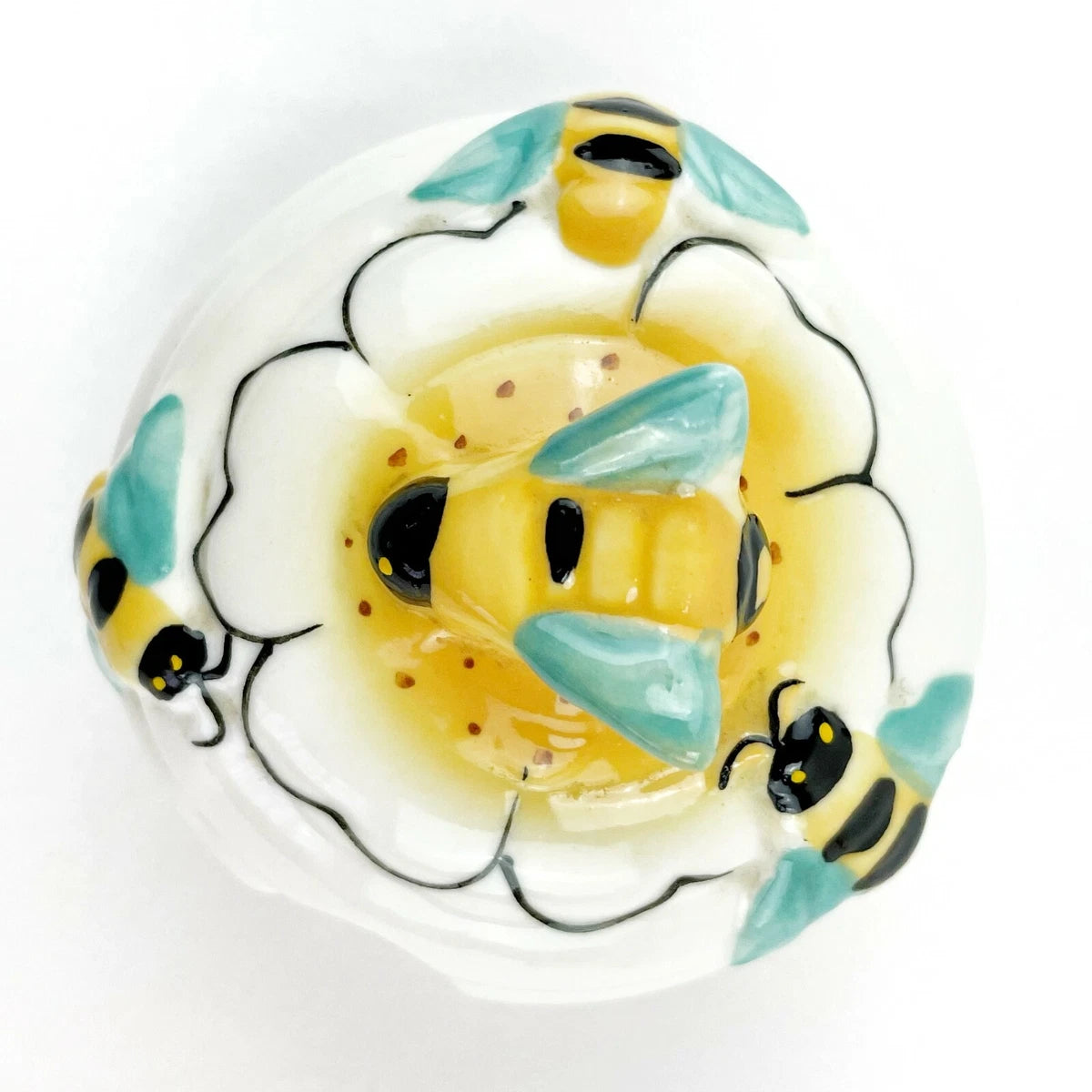 El tarro de miel Beehive de cerámica de 12 oz con dipper y tapa en forma de abeja es un accesorio funcional y decorativo.