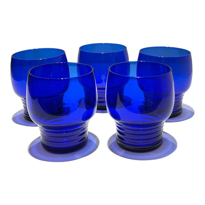 Este set de 2 vasos o  shots tumbler Shaeffer en color azul cobalto, de 3 pulgadas de altura, presenta un diseño clásico de vidrio de depresión.