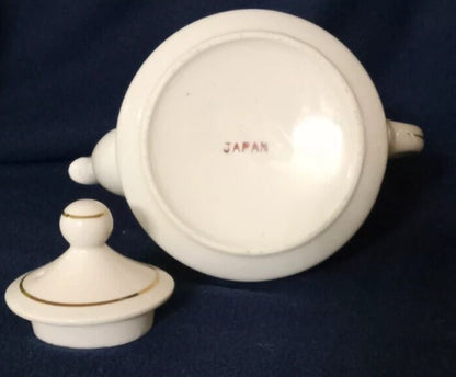 La tetera de cerámica vintage, fabricada en Japón, presenta un diseño de paisaje rural pintado a mano y un borde plateado. 11cm de alto 10cm diámetro.