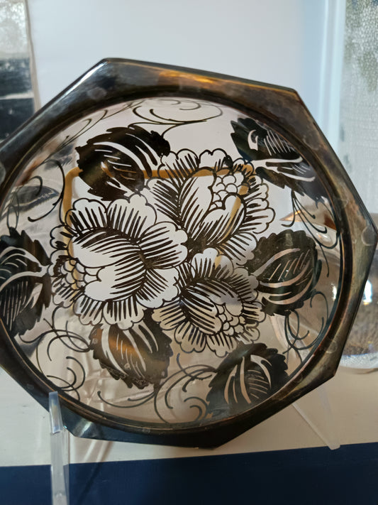 Este plato o bowl de diseño octagonal presenta un borde metálico y un elegante motivo floral en negro. Con un diámetro de 12 cm y una profundidad de 2.5 cm, es ideal para porciones controladas.