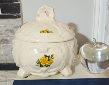 Joyero o bombonera de cerámica blanca presenta un diseño victoriano con relieve ondulado con rosas amarillas pintadas a mano. Medidas 17cm alto 10cm ancho de 13cm largo.