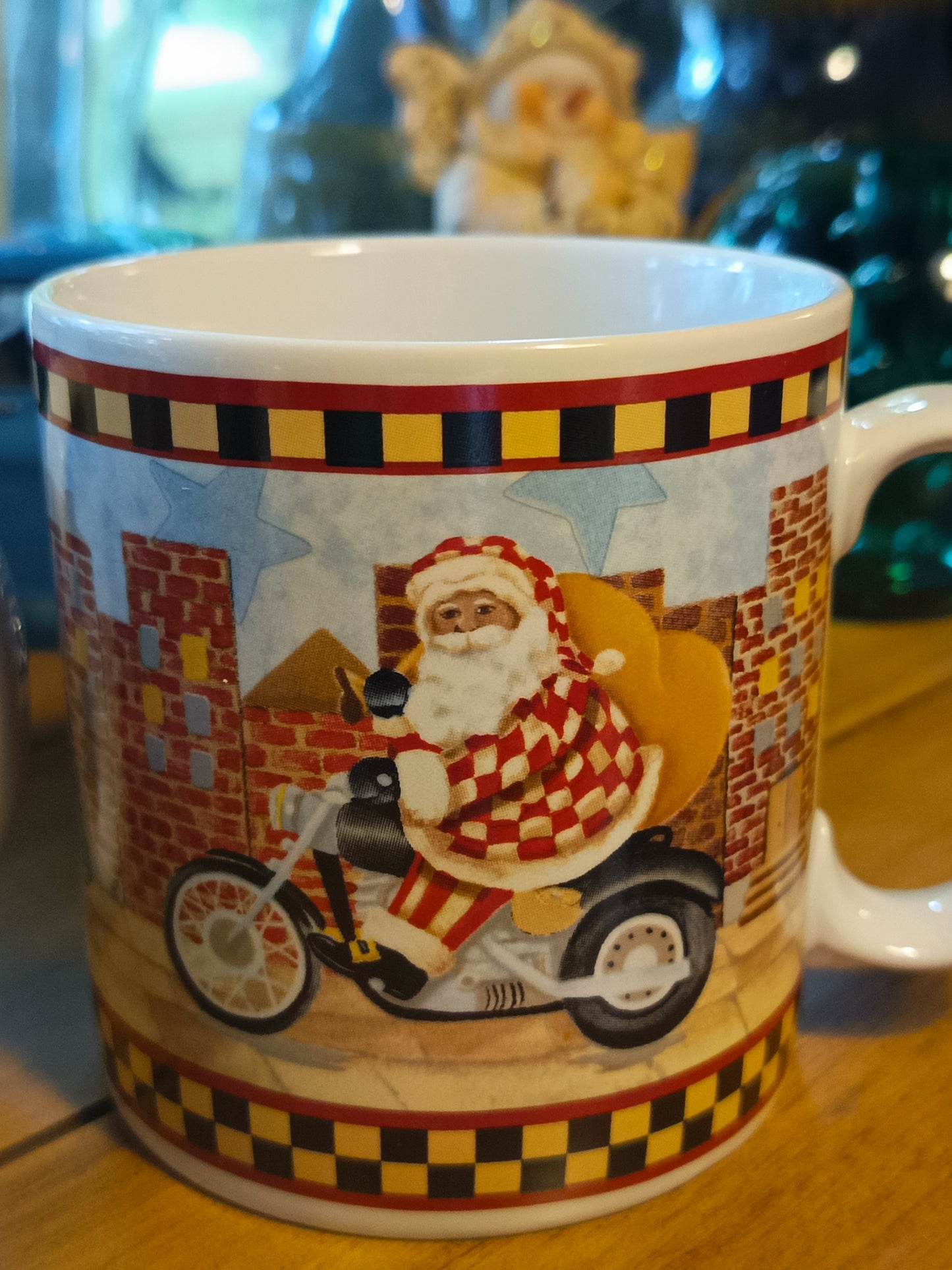 Este set de 4 tazas navideña de café "Santa's Spirit" de Debbie Mumm para Sakura tiene una capacidad de 12 onzas y un diseño navideño con borde a cuadros.