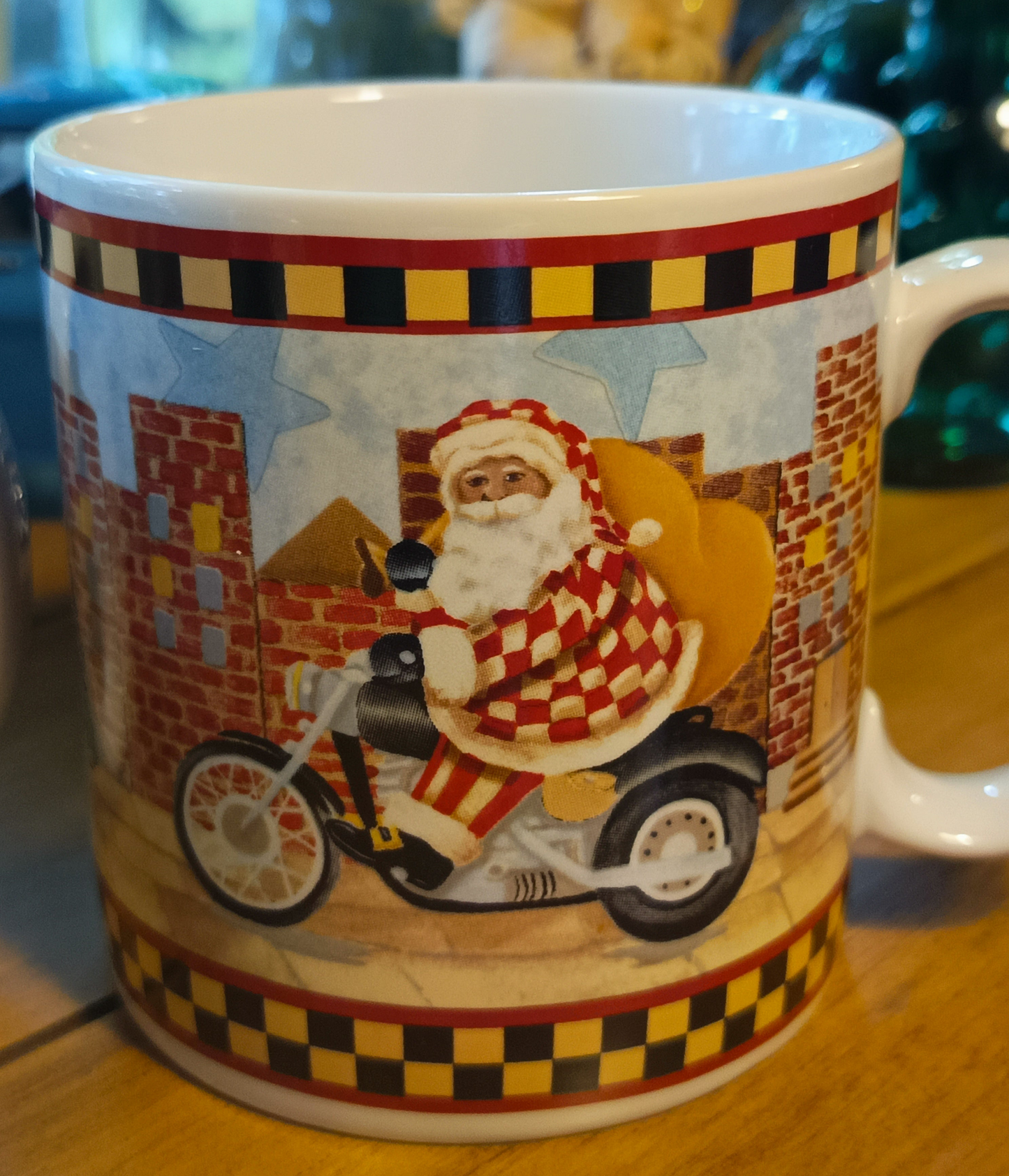 Este set de 4 tazas navideña de café "Santa's Spirit" de Debbie Mumm para Sakura tiene una capacidad de 12 onzas y un diseño navideño con borde a cuadros.